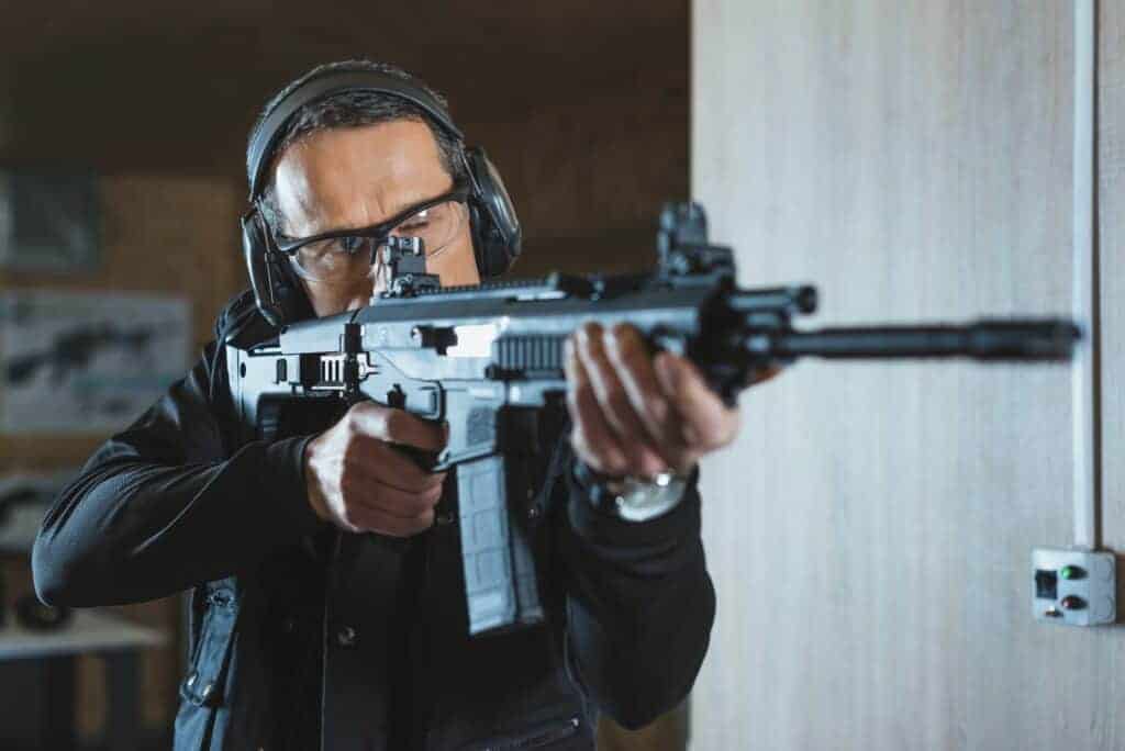 handsome man aiming rifle in shooting range