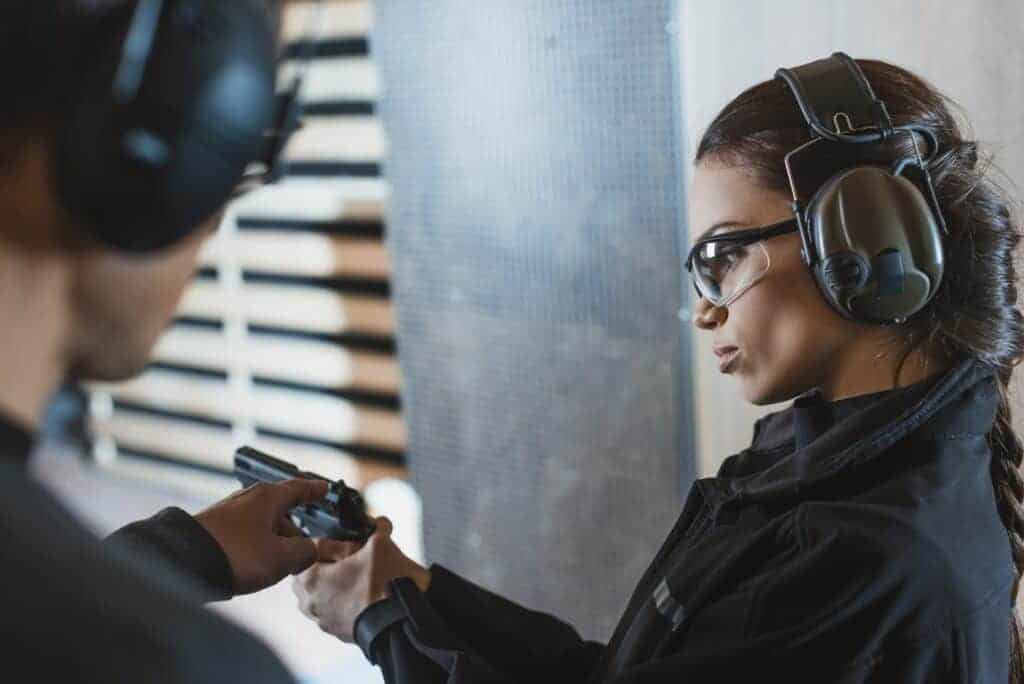 instructor describing gun to client in shooting range