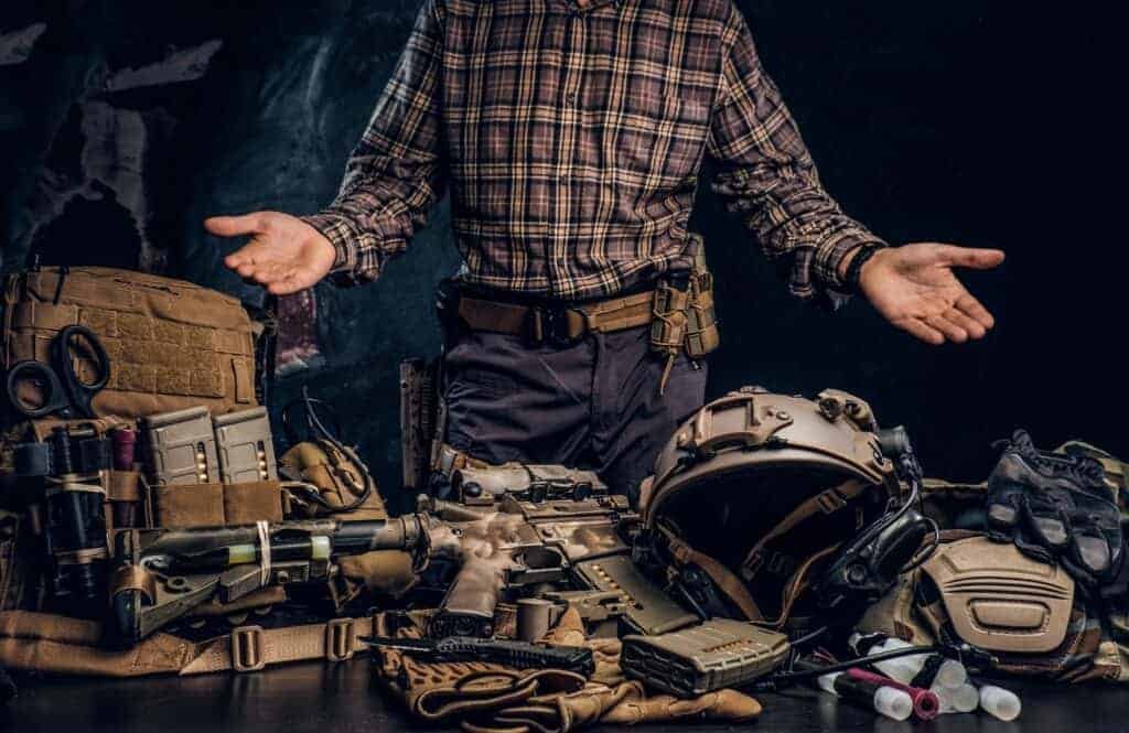 Man in a checkered shirt showing his military uniform and equipment