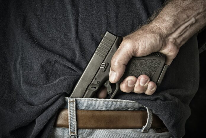 Man pulling gun from waistband