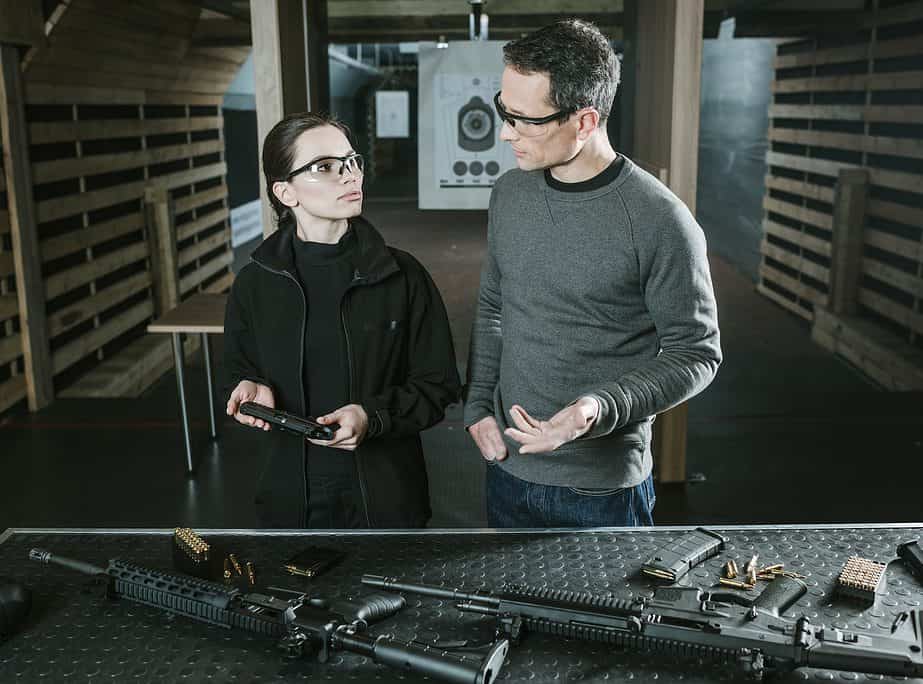 instructor describing gun to female client in shooting range