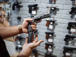 Man choosing new handgun in gun shop