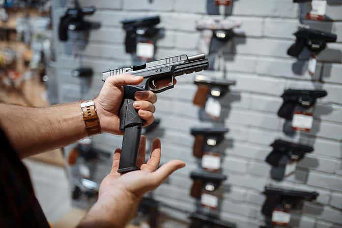 Man choosing new handgun in gun shop